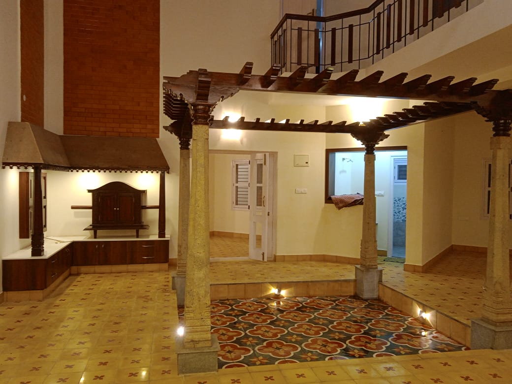 Chettinadu style courtyard with wooden pergola and granite pillars in Mysore home