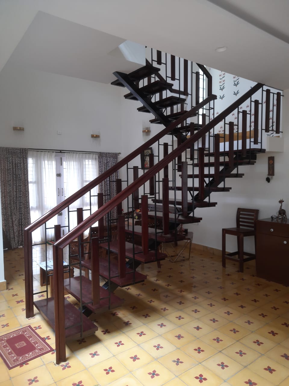 Wooden staircase with ornate railing in Chettinadu style Mysore home