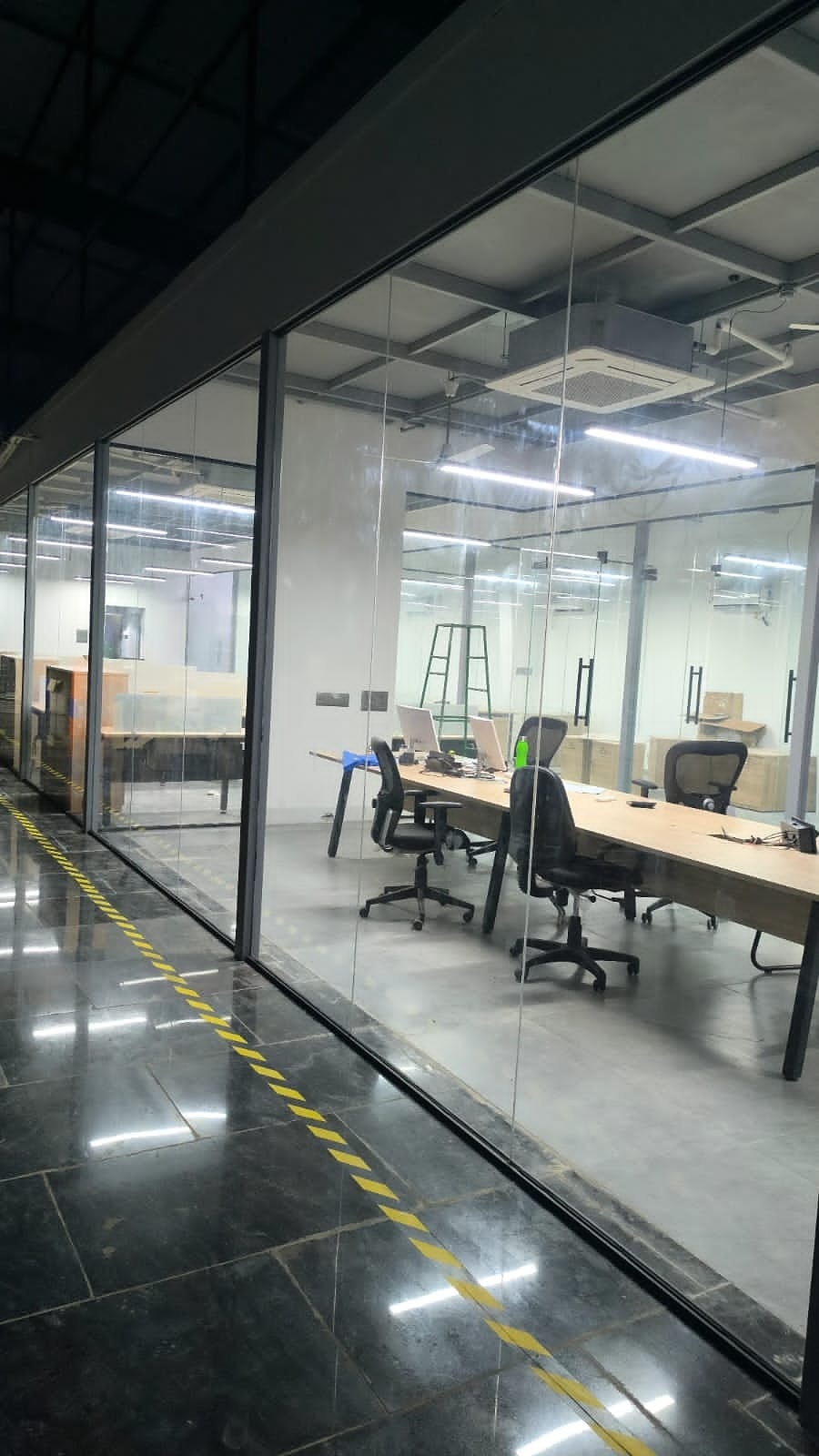 Glass conference room with cubicles beyond