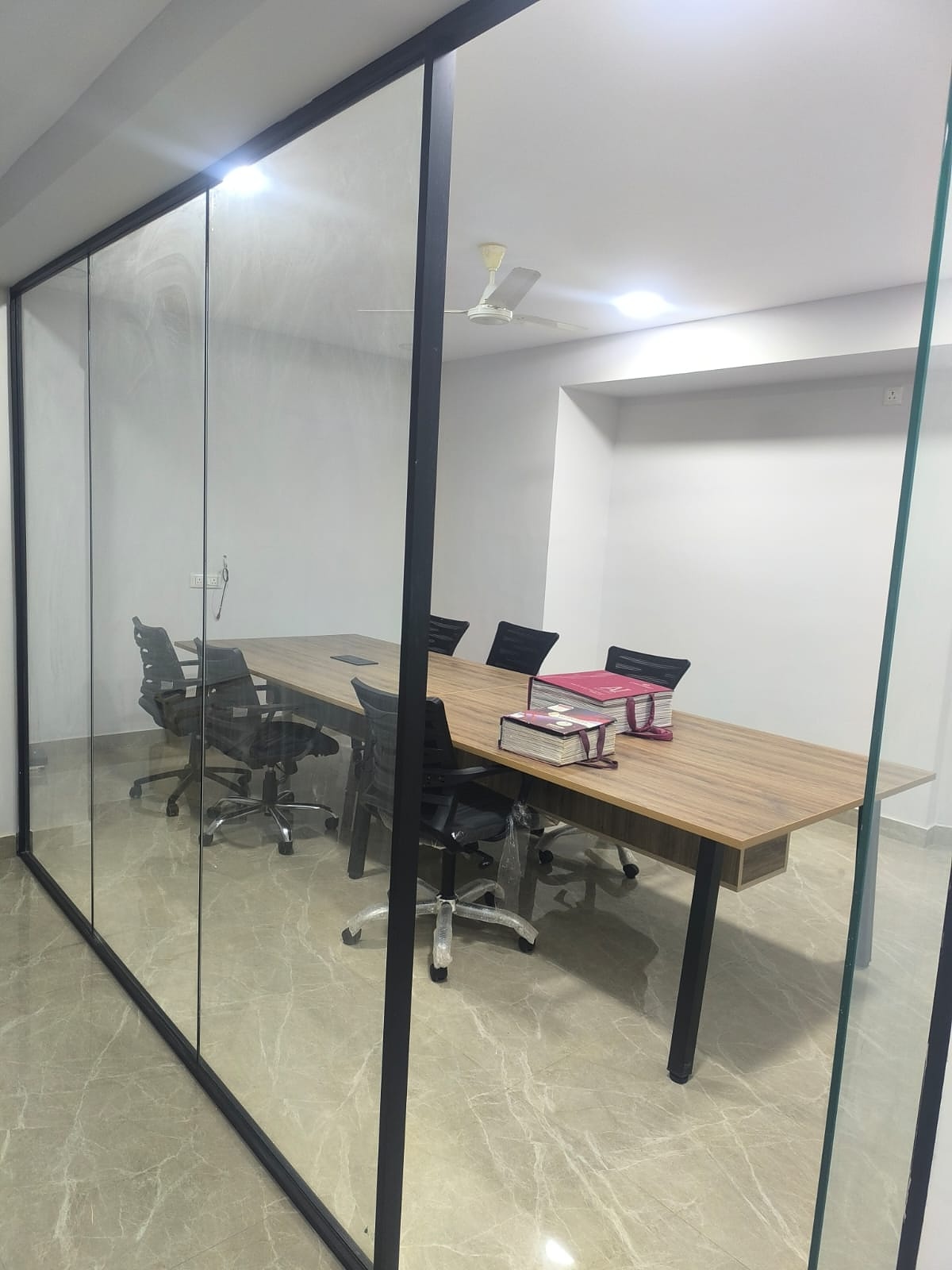 Small glass meeting room with wood table
